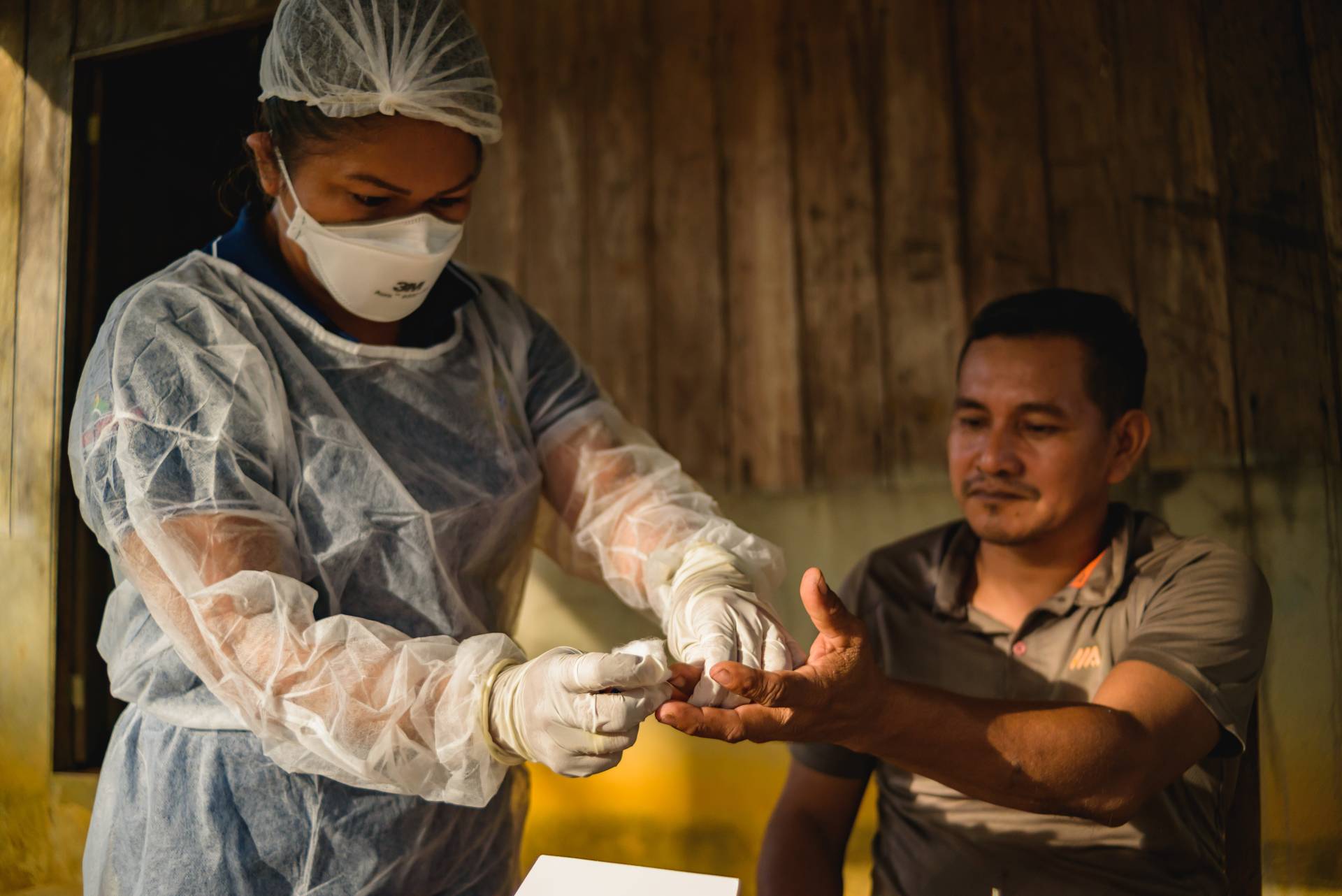 Profissional da saúde realizando consulta popular em comunidade indígena no Amazonas.