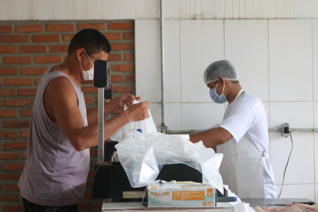 Homem comprando Pirarucu, peixe típico da Amazônia, durante feira realizada pela Fundação Amazônia Sustentável (FAS).