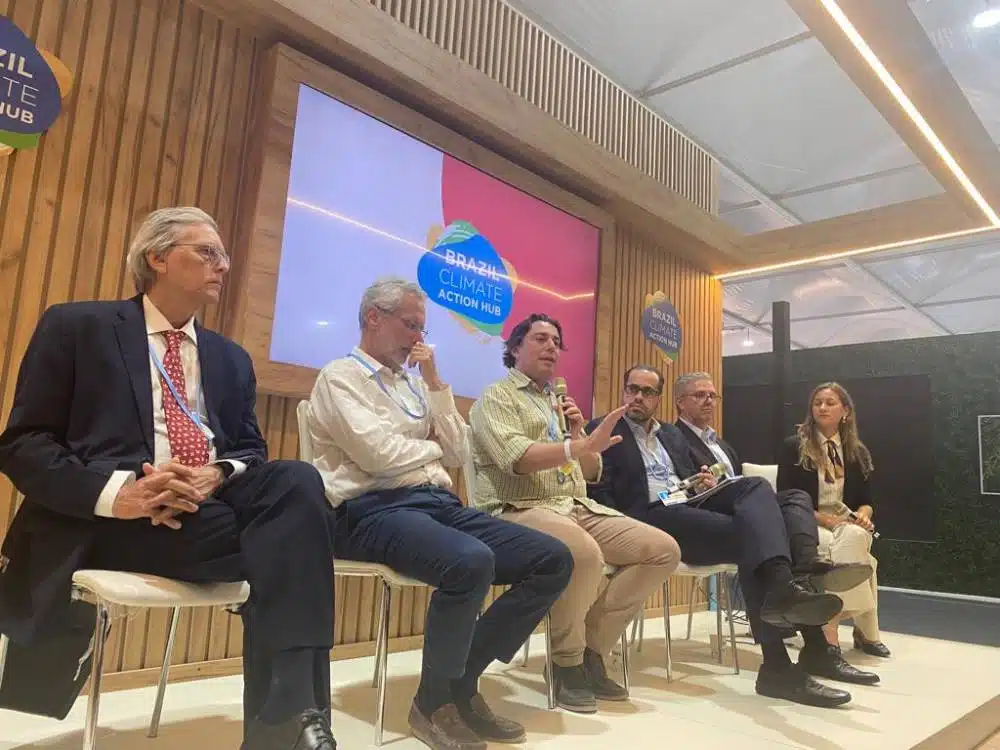 Grupo reunido na 27ª Conferência das Nações Unidas sobre Mudanças Climáticas, falando sobre a regulação do mercado de carbono.