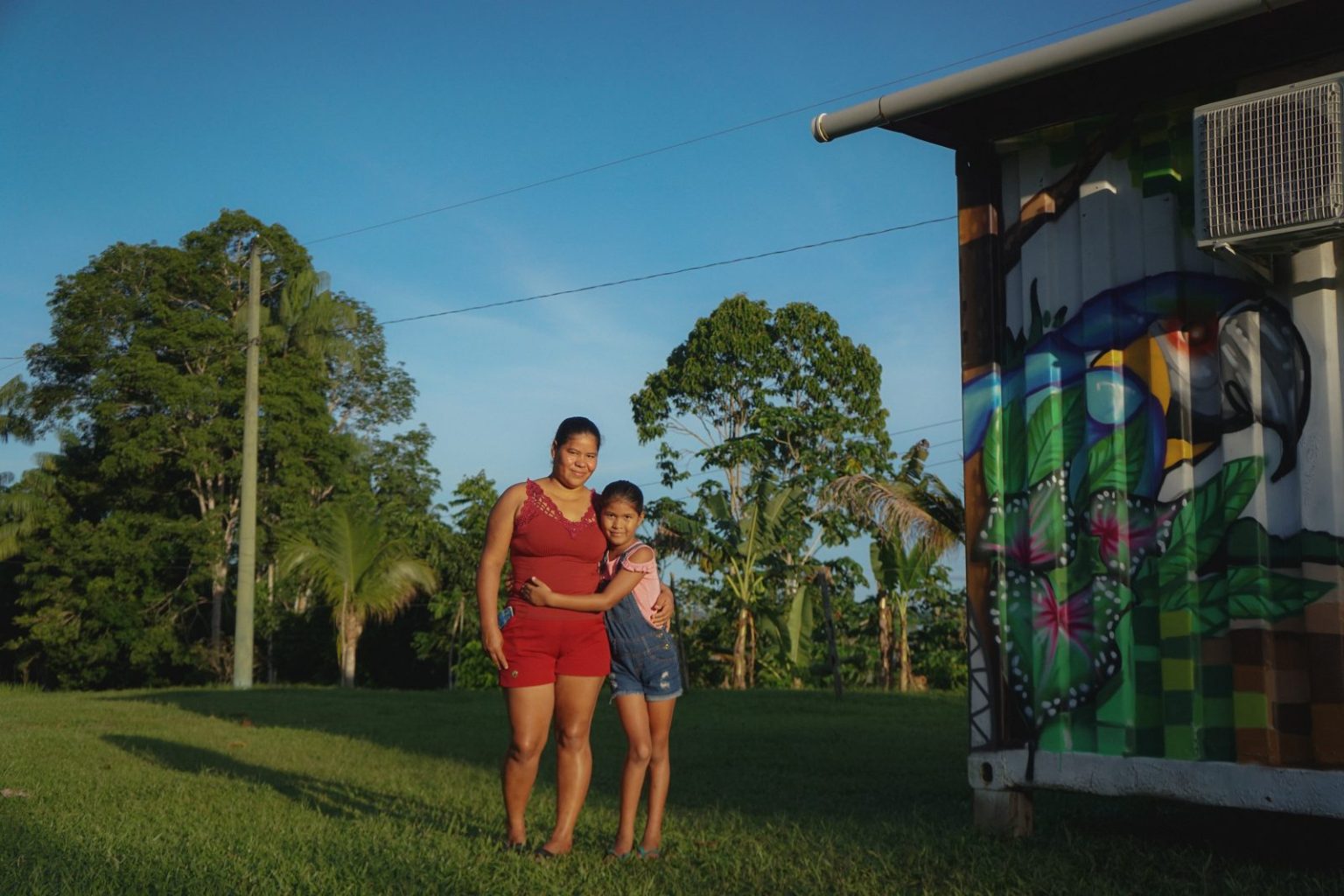 Mãe e filha caminhando juntas em comunidade no interior do Amazonas.