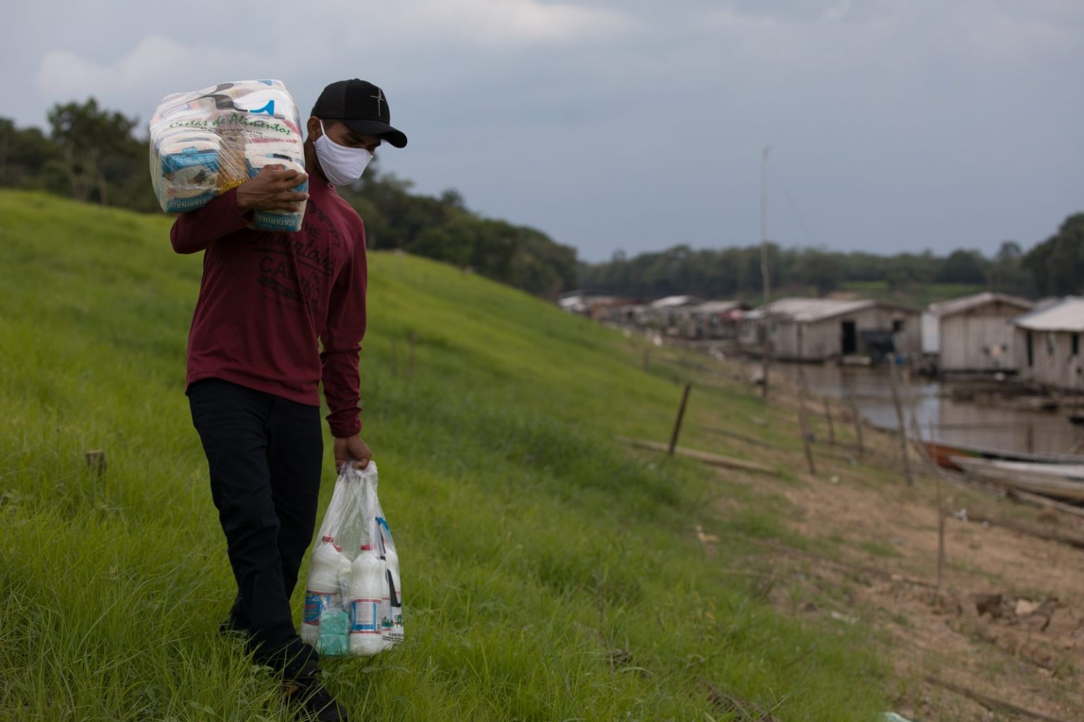 Homem carregando cesta básica que foi doada através da Fundação Amazônia Sustentável (FAS).